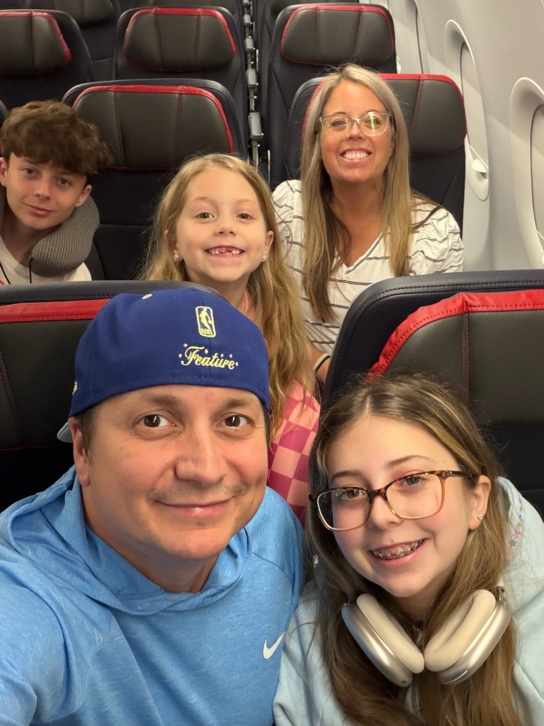 Niko's selfie in airplane seats with Kennedy, Sawyer, Devon, and Maddox