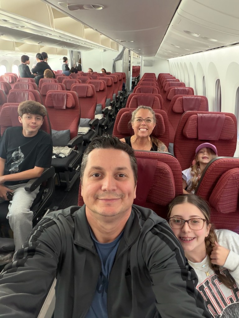 The Nickolaou family together in airplane seats with red headrests