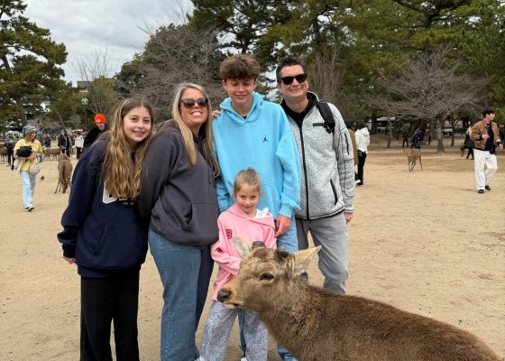 Full Nickolaou family group photo in Nara Park with a deer photobombing