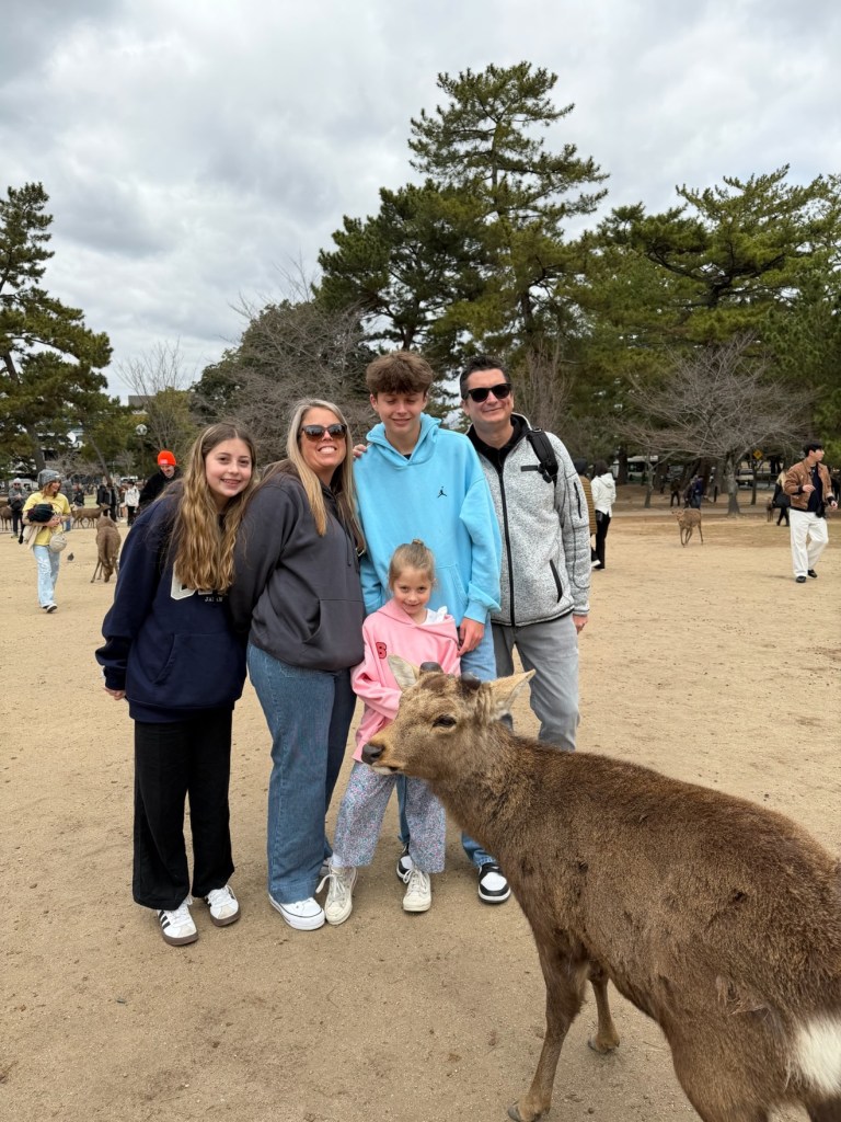 Full Nickolaou family group photo in Nara Park with a deer photobombing