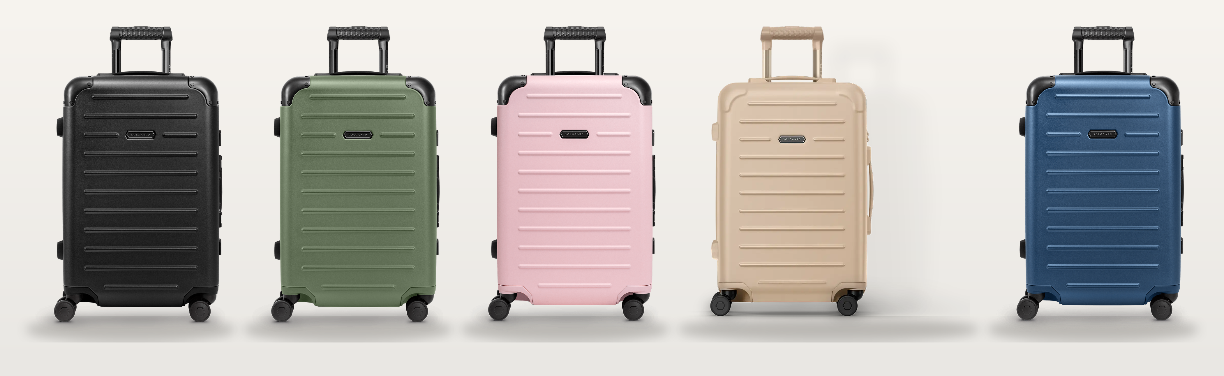 Five Solgaard carry-on bags lined up in black, sage green, pink, beige, and blue